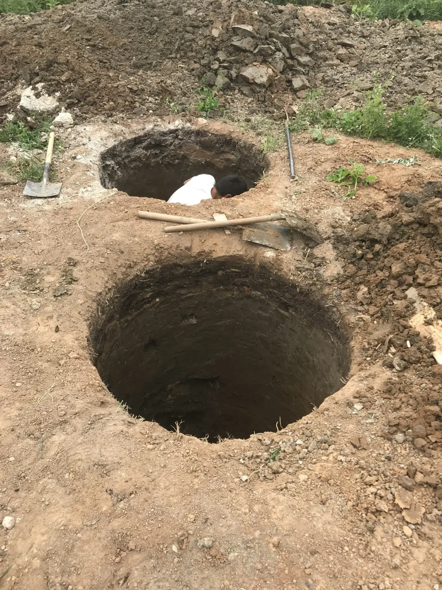 Выкопанная шахта под бетонные кольца септика на участке в городе Руза